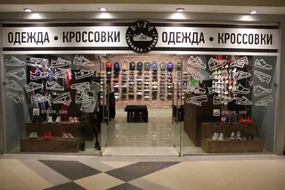 Вывеска «Одежда · кроссовки» над витриной