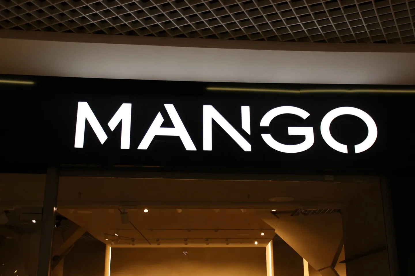 Белые буквы MANGO над входом в магазин