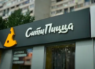 Название пиццерии и знак над витриной